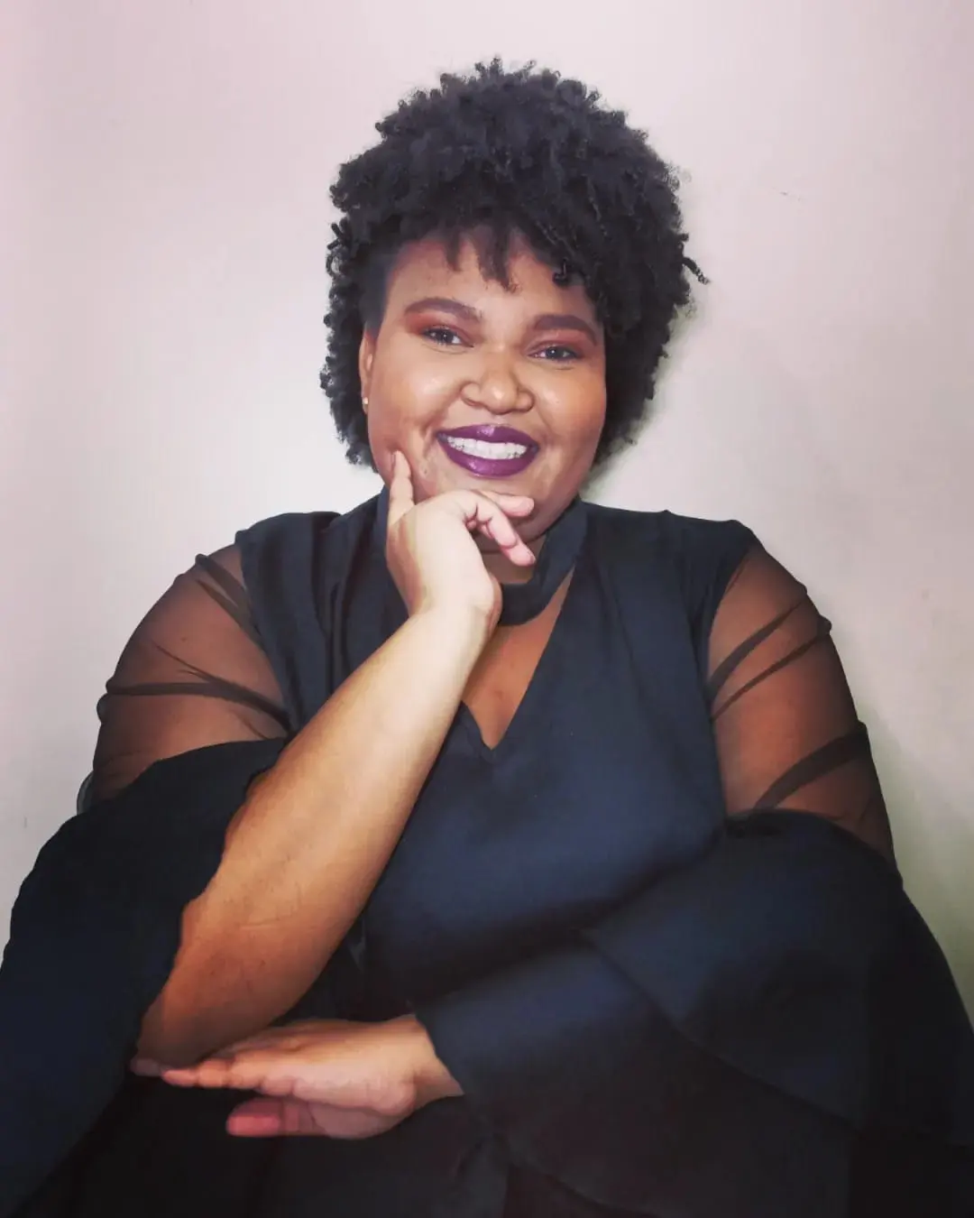 Iris Karoline sentada à mesa, sorrindo